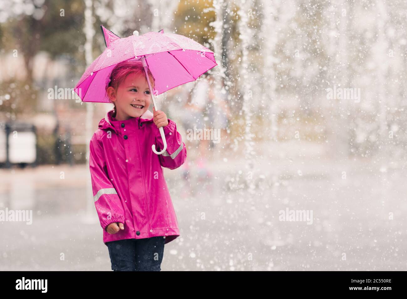 Rire enfant fille 4-5 ans tenant parapluie rose port imperméable sur la  pluie à l'arrière-plan de près dans le parc. Enfance. Saison d'automne  Photo Stock - Alamy