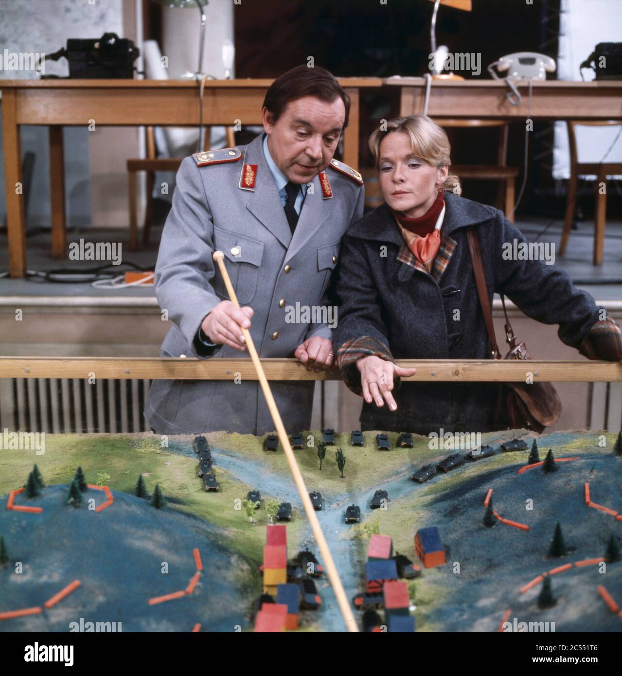 Claudia Butenuth als Lehrer lässt sich von Peter Oehme als General erklären, wie sich die Bundeswehr in Simulationen auf den Ernstfall eines Einsatzes vorbereitet in Planübungen, Regie: Wolfgang Petersen, 1977. Peter Oehme, en tant que général, explique à Claudia Butenuth dans le rôle d'un enseignant comment les forces armées allemandes utilisent des simulations de bataille pour se préparer à la vraie chose à Planübungen, Directeur: Wolfgang Petersen, 1977. Banque D'Images