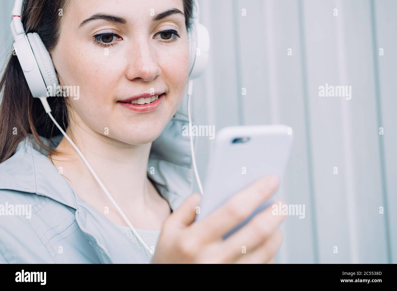 Une fille caucasienne dans un casque écoute un message audio. Banque D'Images