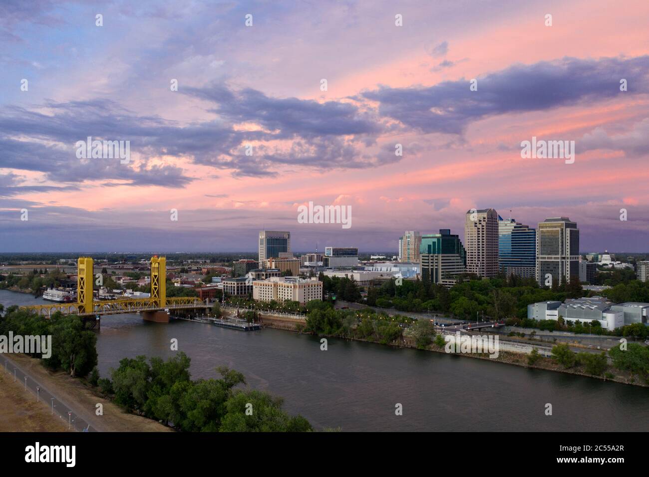 Vue aérienne d'un ciel rose au coucher du soleil sur le centre-ville de Sacramento, la rivière et le Tower Bridge de couleur or Banque D'Images