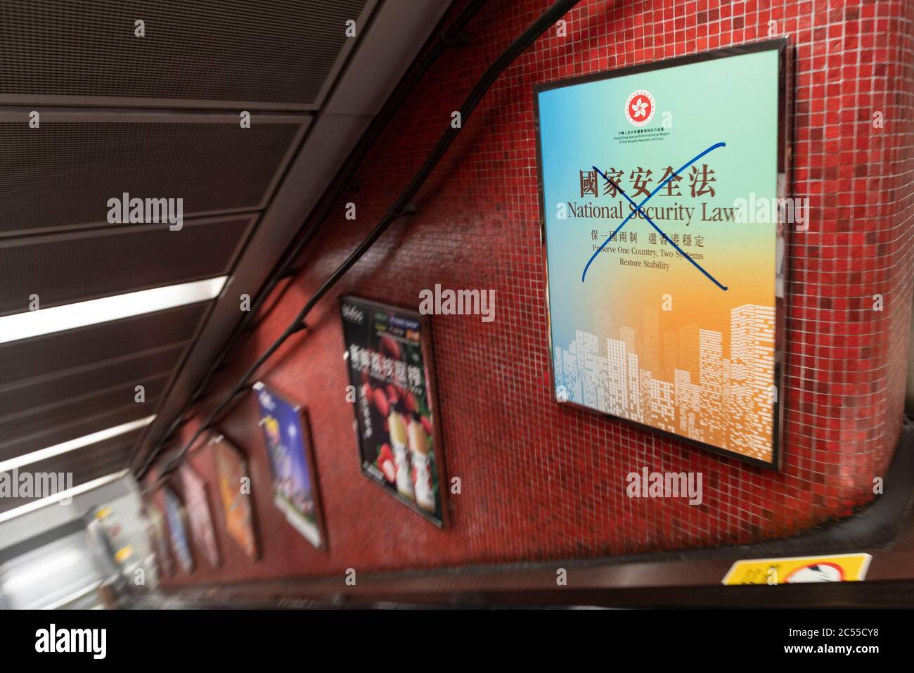 Hong Kong, Chine. 30 juin 2020. Un graffiti croisé est visible sur une publicité parrainée par le gouvernement faisant la promotion de la nouvelle loi de sécurité nationale sur l'escalier roulant de MTR à Hong Kong le 30 juin 2020 crédit: May James/ZUMA Wire/Alamy Live News Banque D'Images