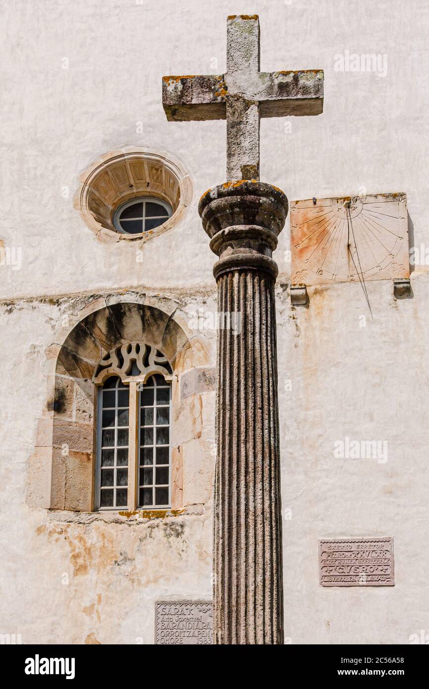 Croix en pierre et cadran solaire sur le mur de l'église à Espelette Banque D'Images