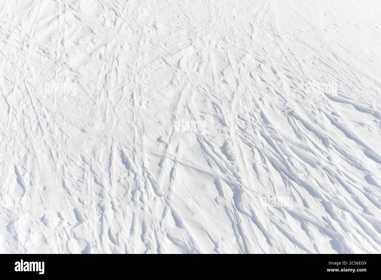 3 - les pistes linéaires légèrement courbés laissées par les skieurs absents se croisent dans un motif en treillis complexe dans la neige alpine blanche pure, texture d'arrière-plan Banque D'Images