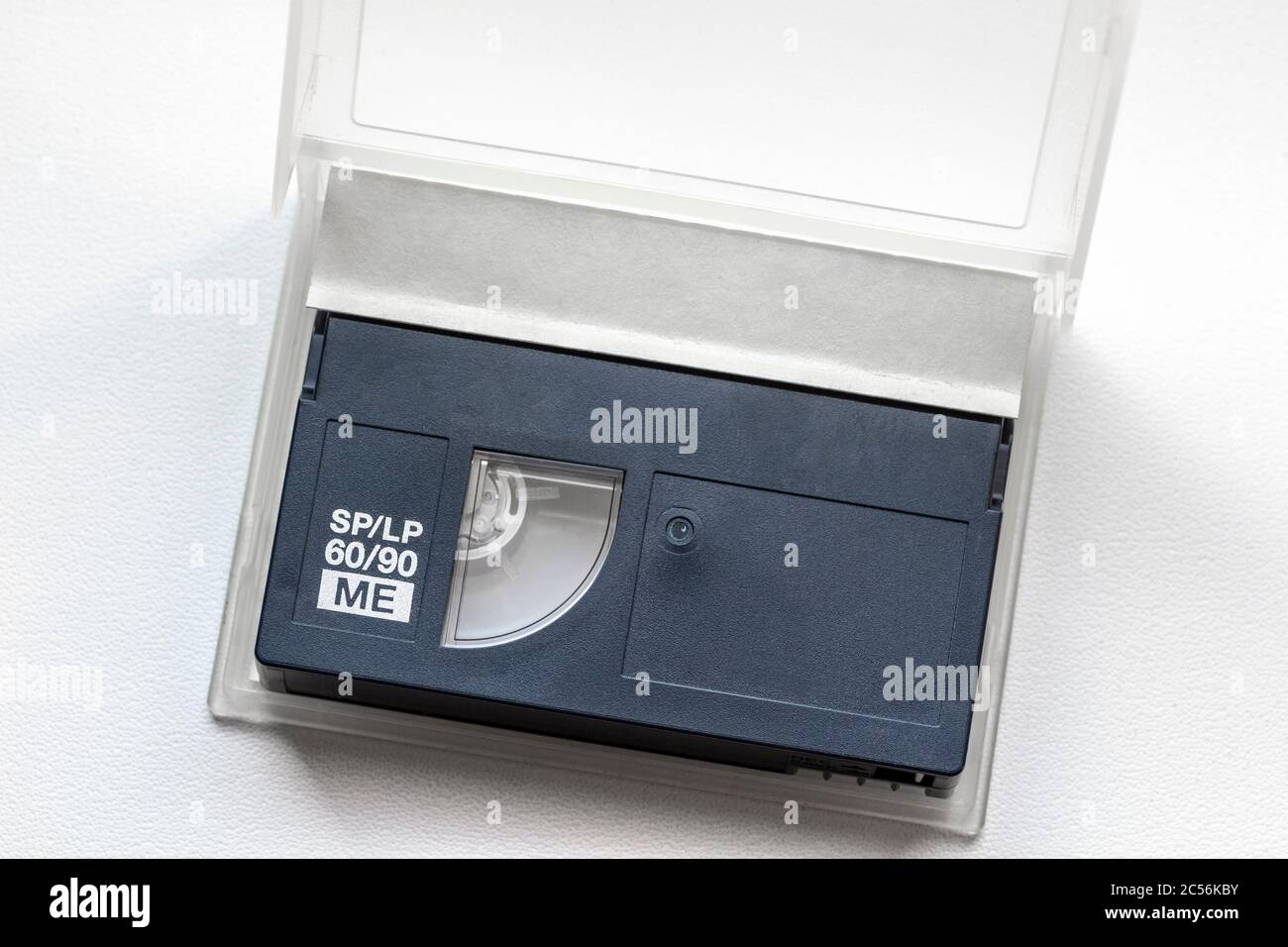 Ancienne mini cassette DV dans un boîtier ouvert sur un rebord de fenêtre blanc. Banque D'Images