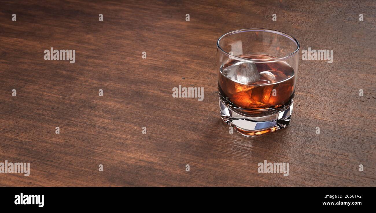 Verre de whisky scotch et de glace. Whisky, bourbon, brandy ou rhum sur une table de restaurant en bois. Verre avec boisson alcoolisée. Banque D'Images