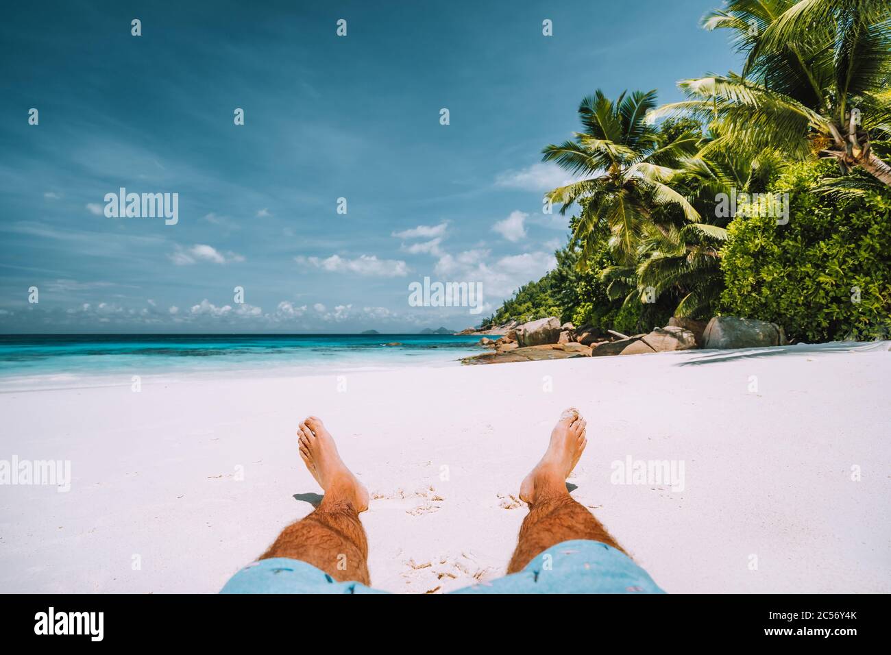 homme reposant sur la plage de sable blanc avec de beaux palmiers. Banque D'Images