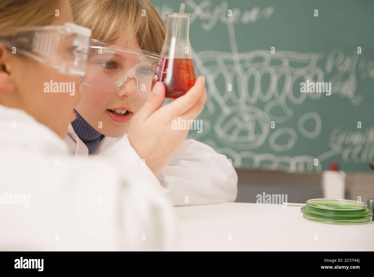 Les élèves du secondaire qui examinent le bécher de liquide en classe scientifique Banque D'Images