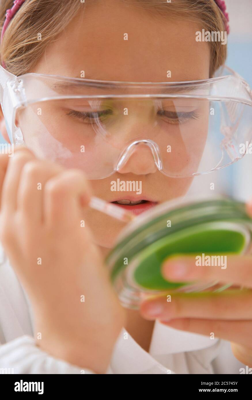 Gros plan jeune fille de lycée dans des lunettes de science avec boîte de Petri Banque D'Images