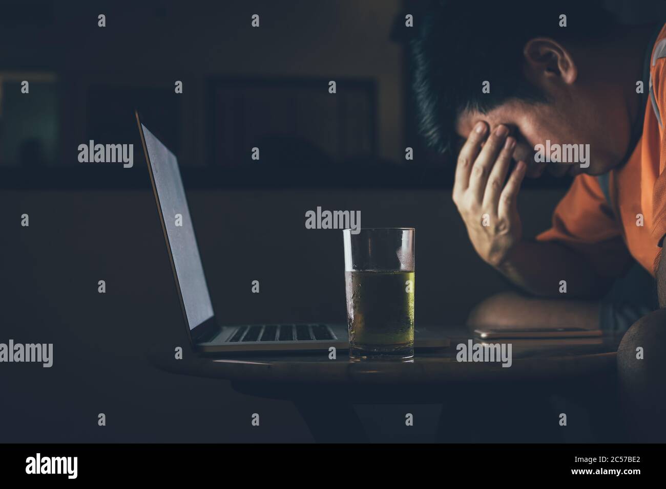 Les hommes boivent de la bière tout en regardant les ordinateurs portables être stressés et tristes. Banque D'Images