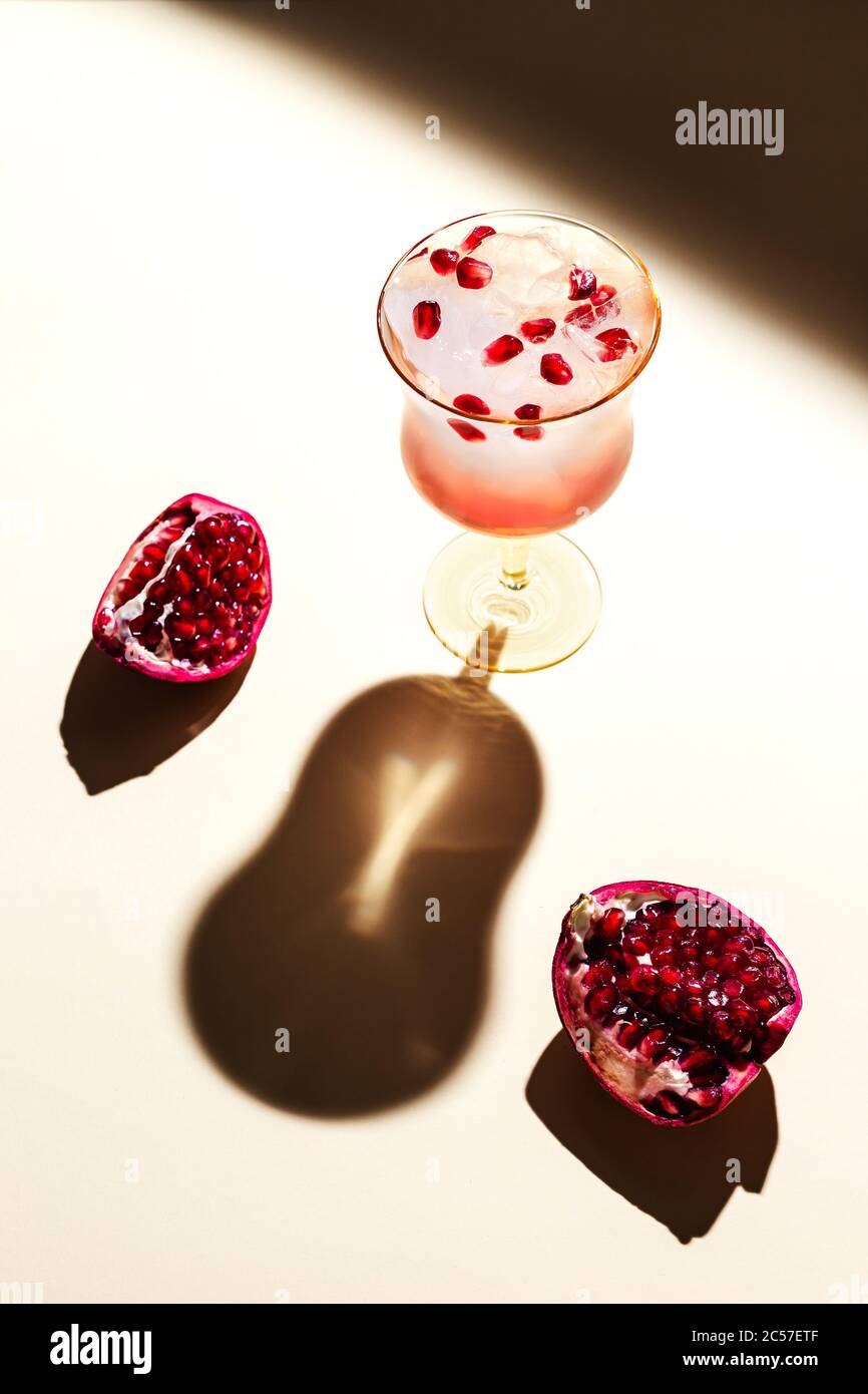 Un beau verre d'eau tonique glacée avec grenade, dos dur, ombres profondes Banque D'Images