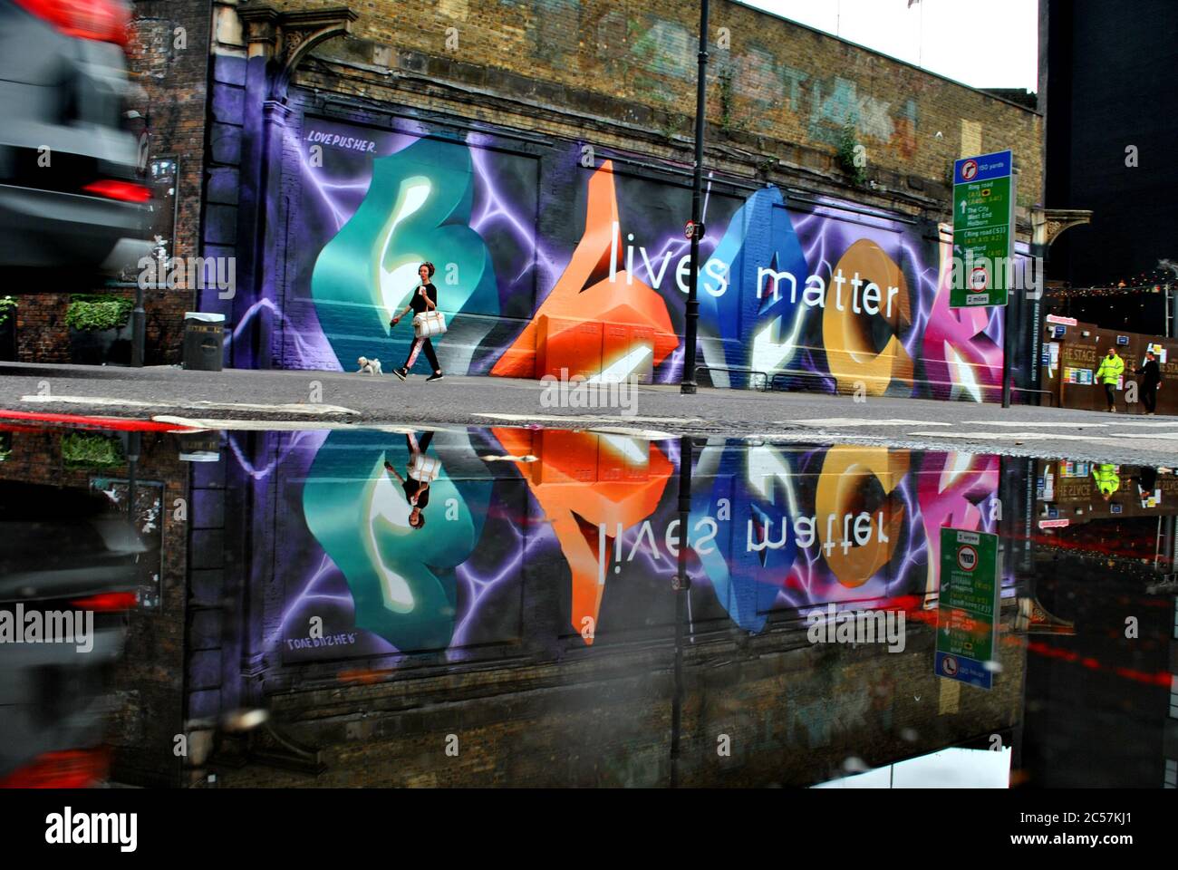 UNE FLAQUE REFLÈTE LA PEINTURE MURALE BLACK LIVES MATTER SUR GREAT EASTERN STREET, LONDRES Banque D'Images
