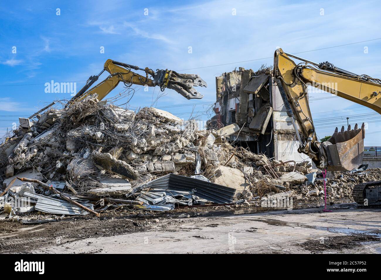 Bâtiment Maison démolition Pelle hydraulique avec site machine crasher et jaune contenant. Banque D'Images