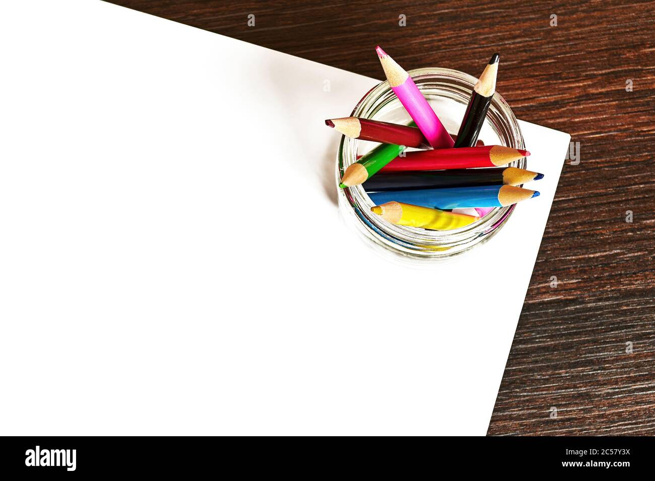 Vue de dessus du bureau pour enfants avec crayons de couleur et feuilles de papier blanc pour le dessin. Modèle d'arrière-plan avec espace de copie pour le texte de publicité Banque D'Images