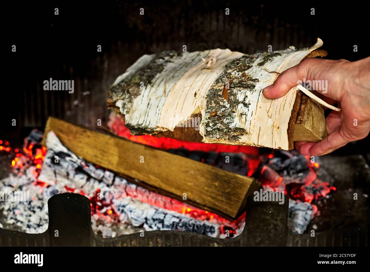 Jetez le bois de chauffage de bouleau dans une cheminée. Réchauffent la maison. Arrière-plans intérieurs Banque D'Images