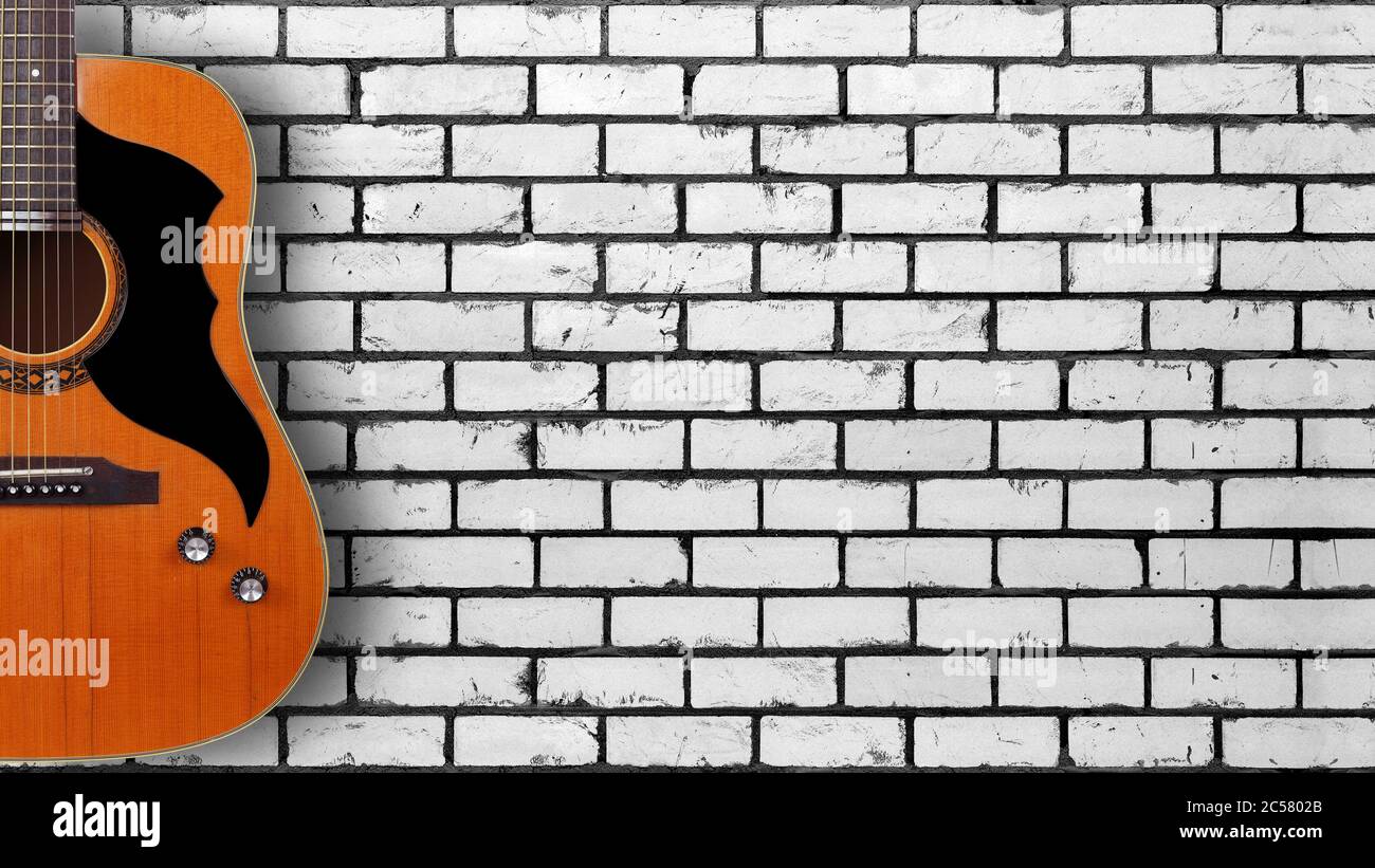 Instrument de musique - Silhouette d'une guitare acoustique vintage sur fond de mur de briques blanches. Banque D'Images