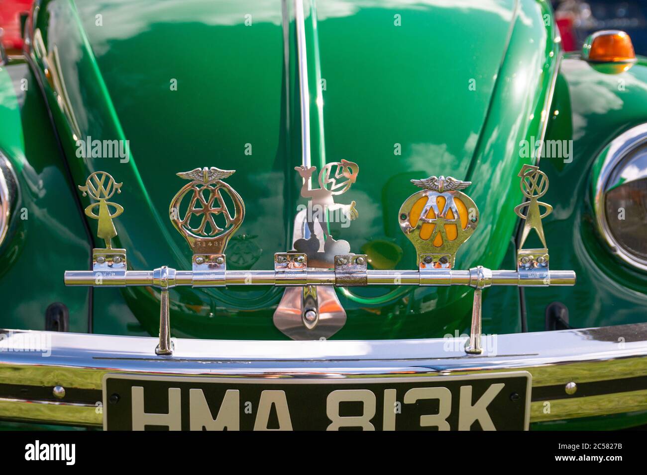 Gros plan sur le classique vert vintage VW Beetle de type 1 au salon de l'auto avec emblèmes de club de voiture sur rail de badge chromé Banque D'Images