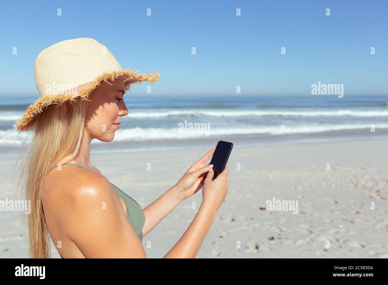 Femme à l'aide du smartphone sur la plage Banque D'Images
