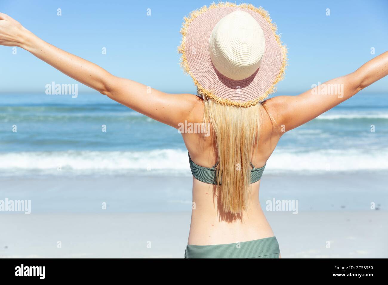 Vue arrière de la femme debout avec ses bras ouverts sur la plage Banque D'Images