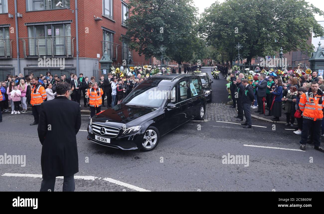 Le cortège funéraire de Noah Donohoe, 14 ans, quitte son école, le collège St Malachy à Belfast, où il s'est mis en pause pendant un court moment flanqué de ses camarades de classe, après son service funéraire privé à l'église Saint Patrick. Banque D'Images