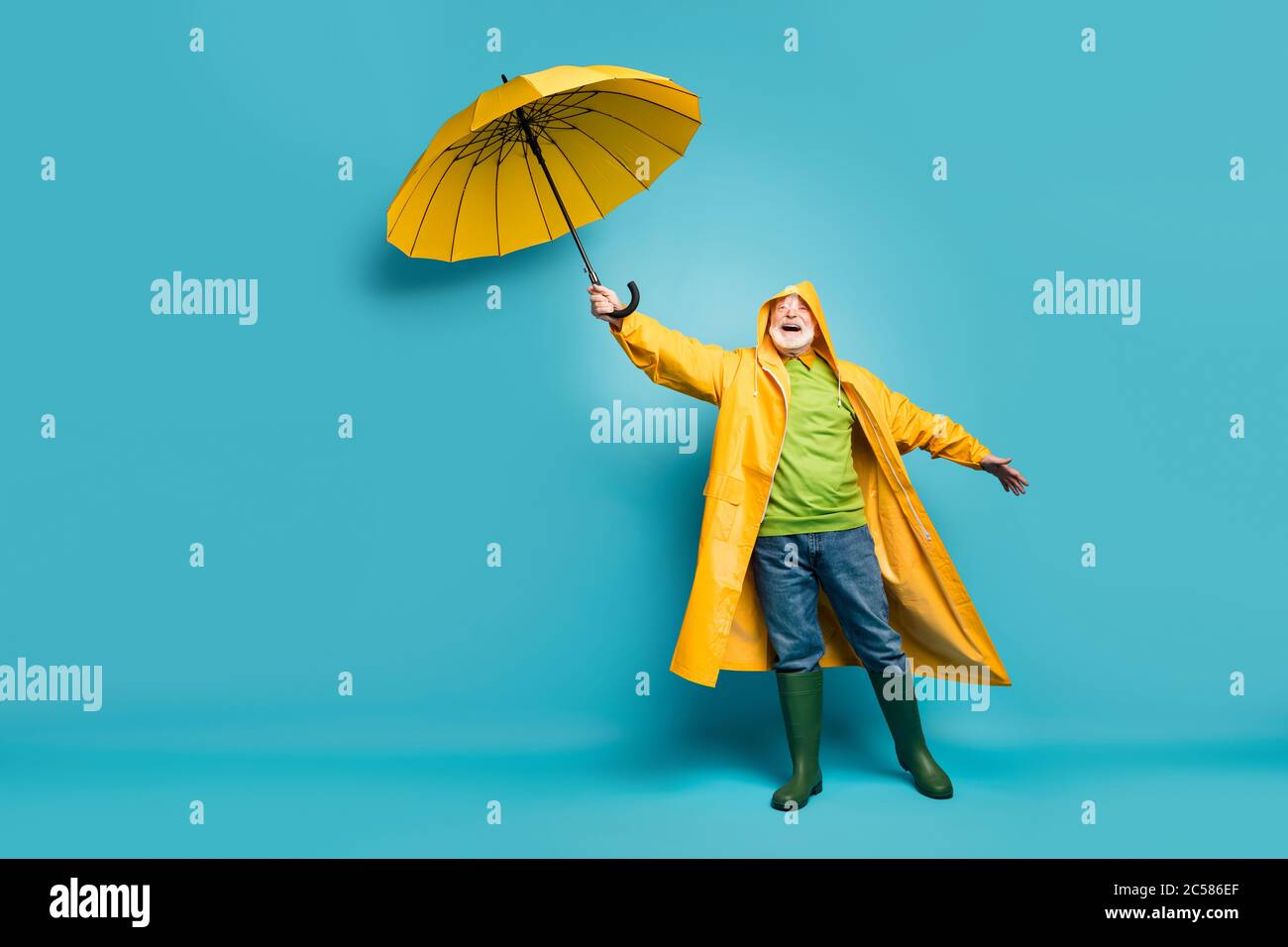 Vue de sa taille de corps pleine longueur de son gai gai chey gris rêveur homme portant la couche supérieure jaune mauvais temps cyclone jour isolé sur lumineux Banque D'Images