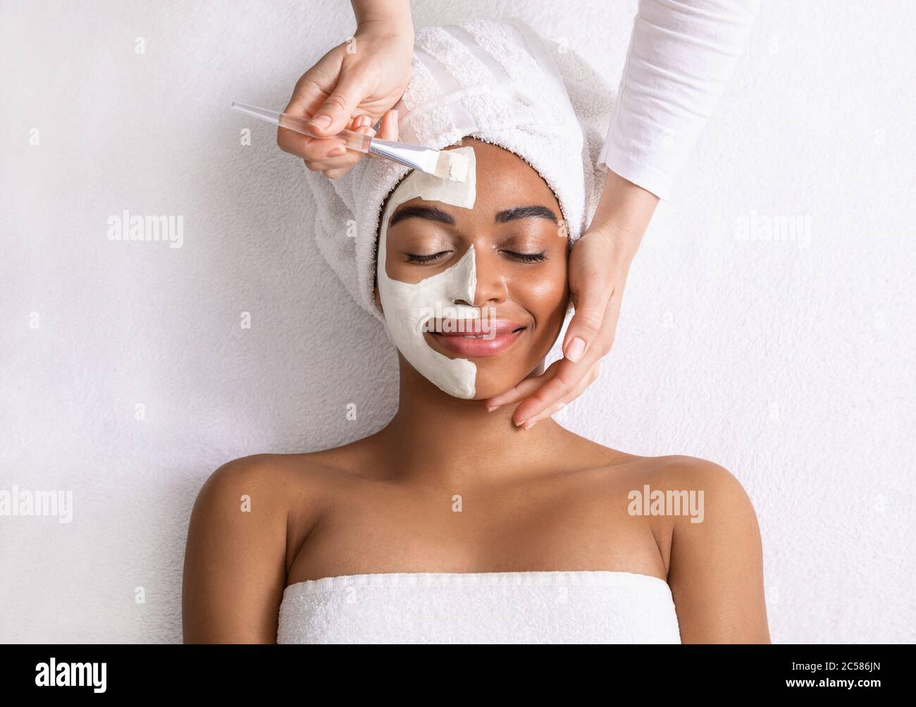 Femme noire avec masque blanc sur la moitié de son visage Banque D'Images