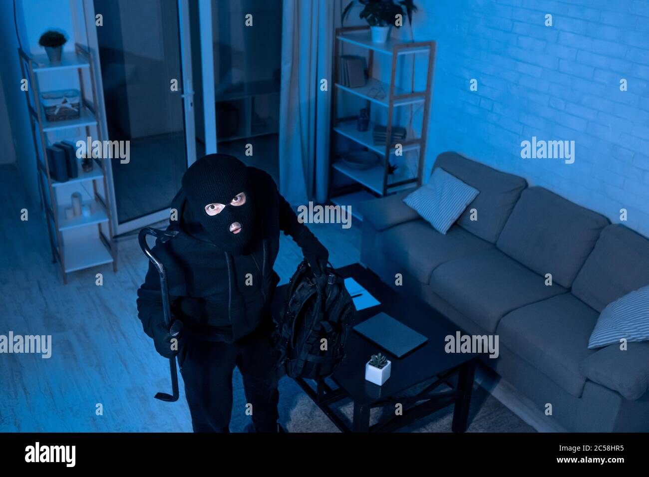 Voleur avec Crowbar entrant dans la vue de la maison depuis la caméra ci-dessus Banque D'Images