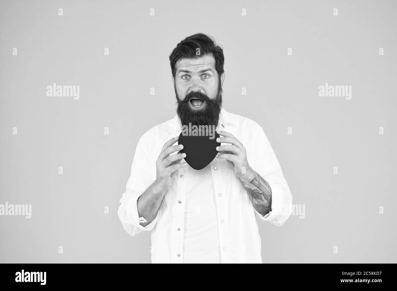 Prescrire des médicaments diminuant la pression artérielle cholestérol. Sentir le rythme cardiaque pouls rythmique. La maladie de coeur. De saines habitudes et style de vie. La surveillance et la mesure. Hipster barbu homme tenir cœur rouge. Banque D'Images