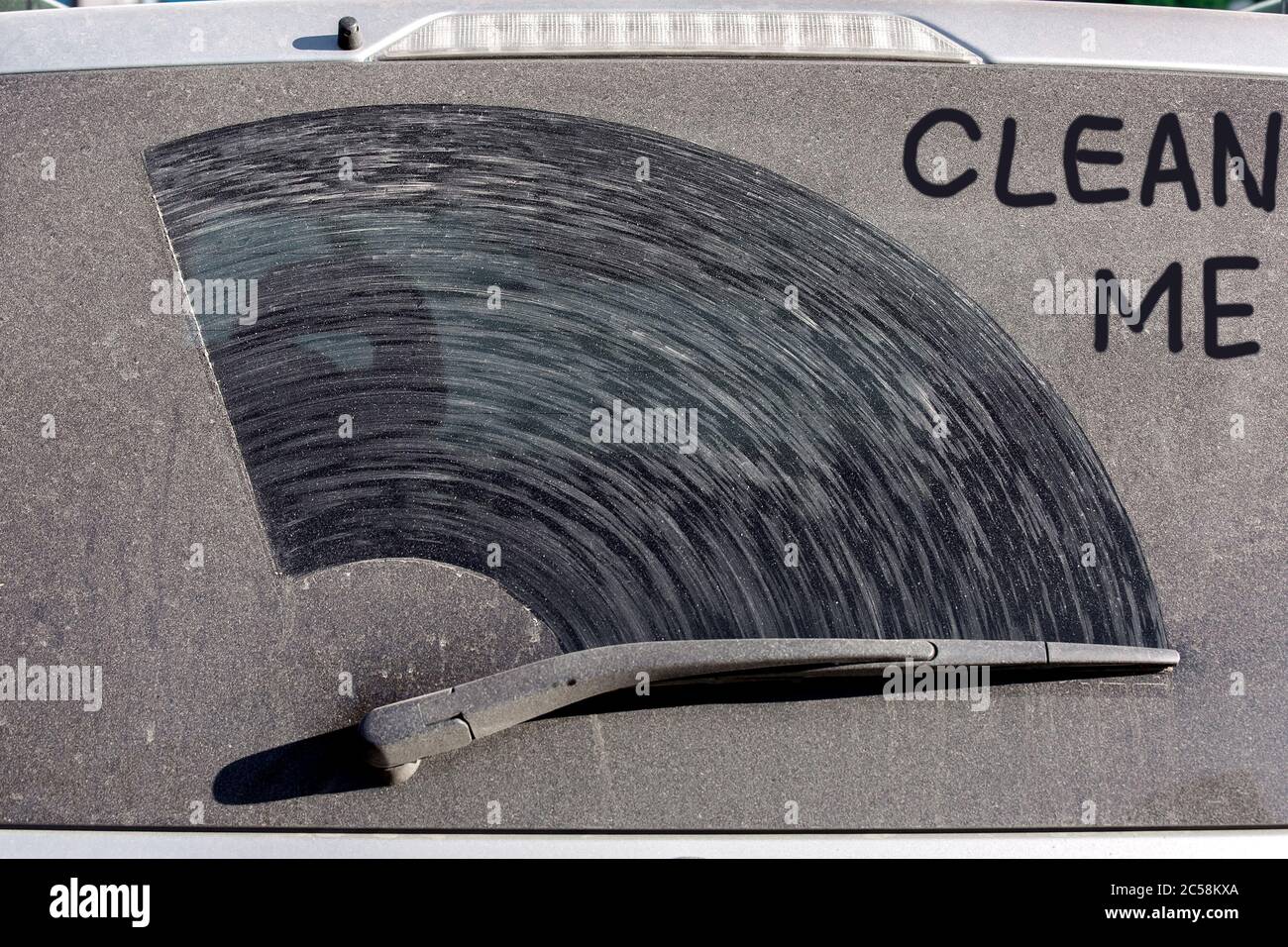 l'inscription clean me sur la lunette arrière d'un vus d'une voiture sale dans une couche de poussière et de saleté sèche, gros plan d'un véhicule sale vue arrière le jour ensoleillé. Banque D'Images