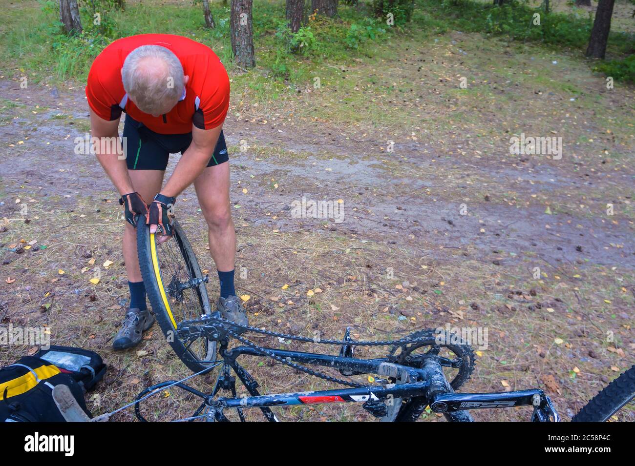 Réparation roue de bicyclette, l'homme percé roue de bicyclette, le trou de roue de bicyclette, forêt, région de Kaliningrad, Russie, Europe de l'Est, le 31 juillet 2019 Banque D'Images