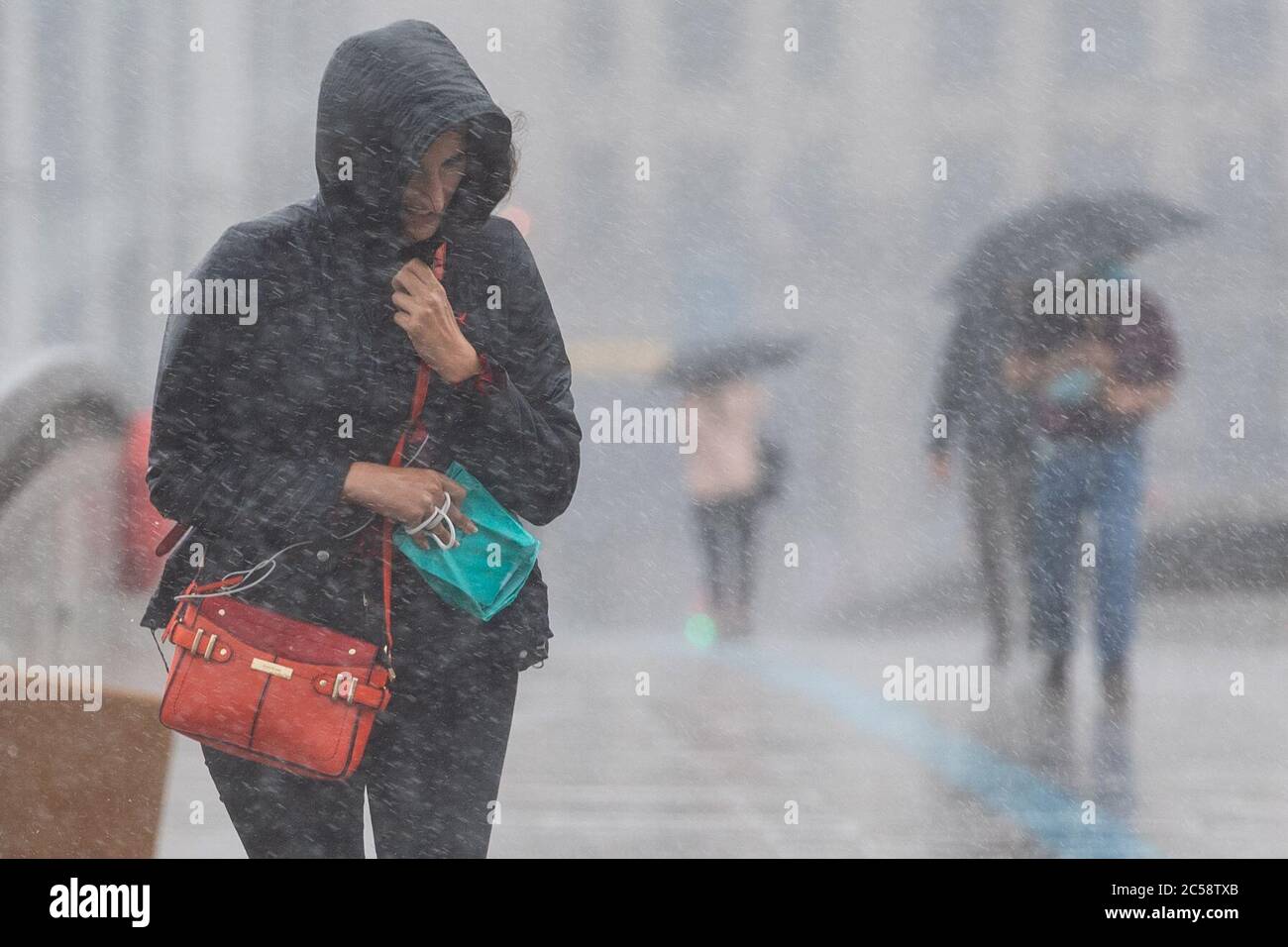 Une femme court pour prendre refuge après une grosse averse sur le London Bridge, dans le centre de Londres. Banque D'Images