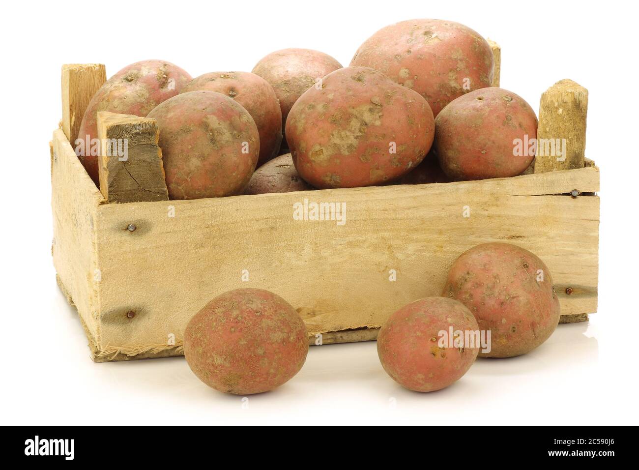 Pommes de terre hollandaises fraîchement récoltées appelées 'Bildtstar' dans une caisse en bois sur fond blanc Banque D'Images