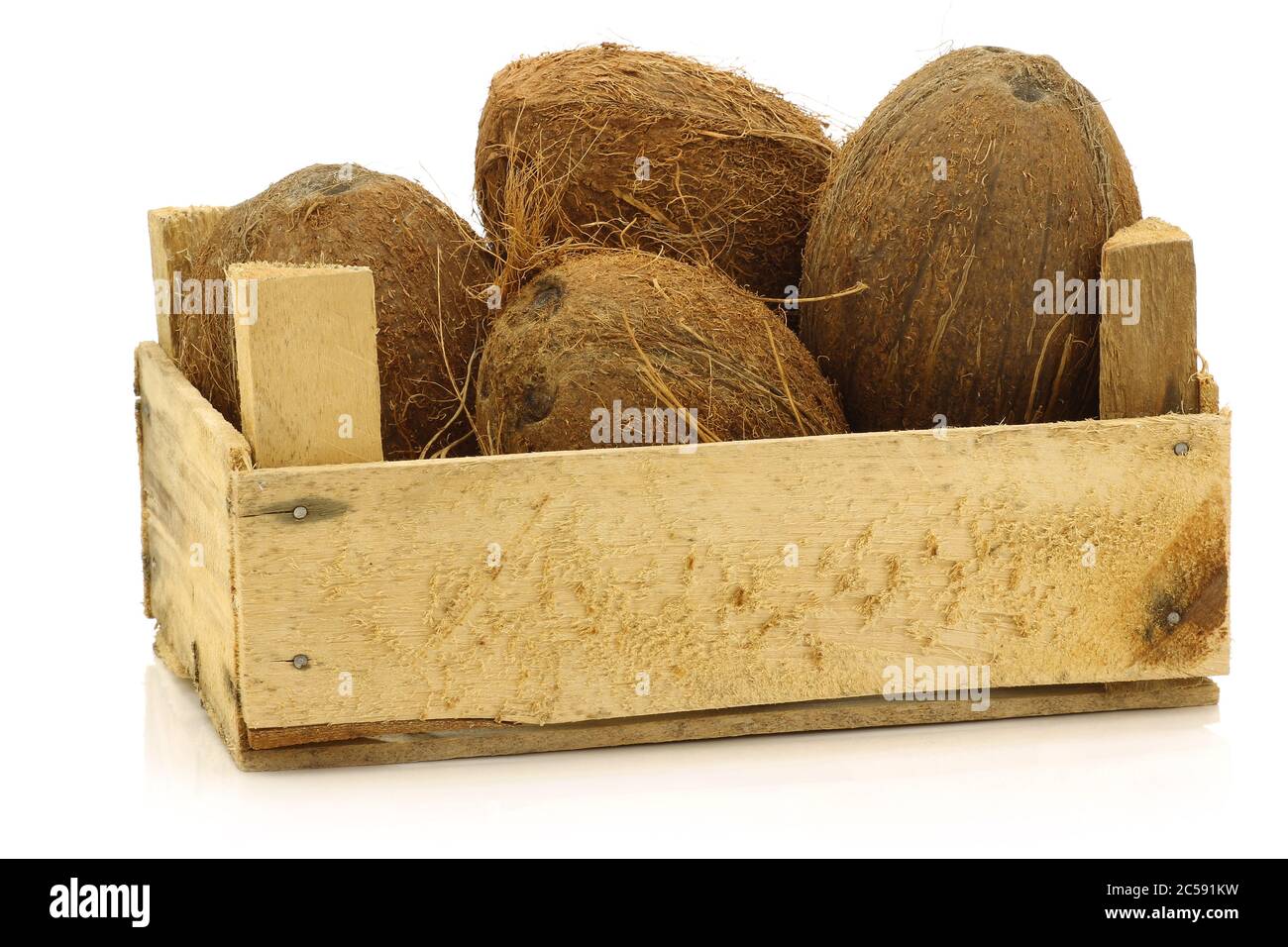 noix de coco fraîches dans une caisse en bois sur fond blanc Banque D'Images