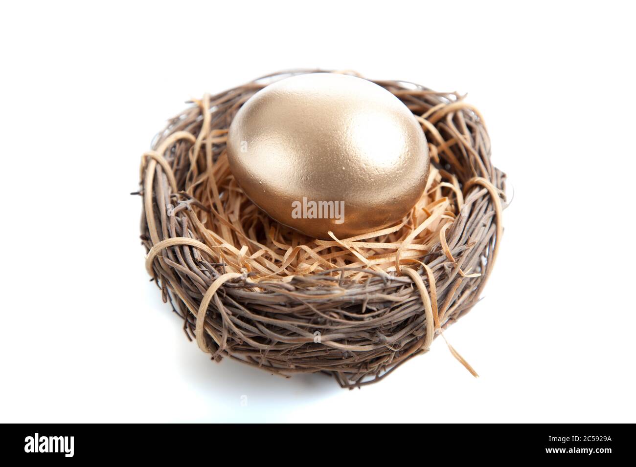 Un œuf d'or en nid sur fond blanc Banque D'Images