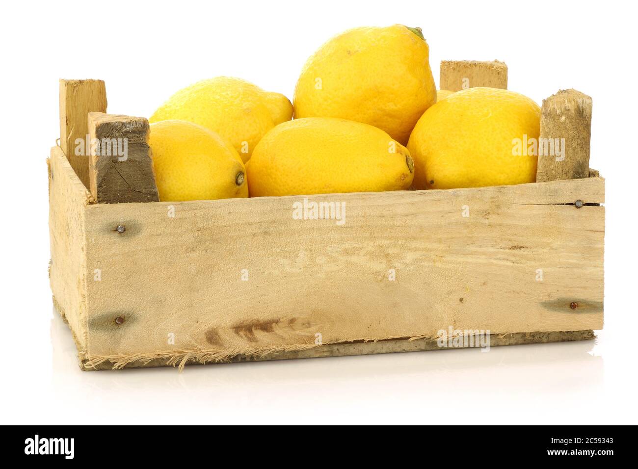 citrons frais dans une boîte en bois sur fond blanc Banque D'Images