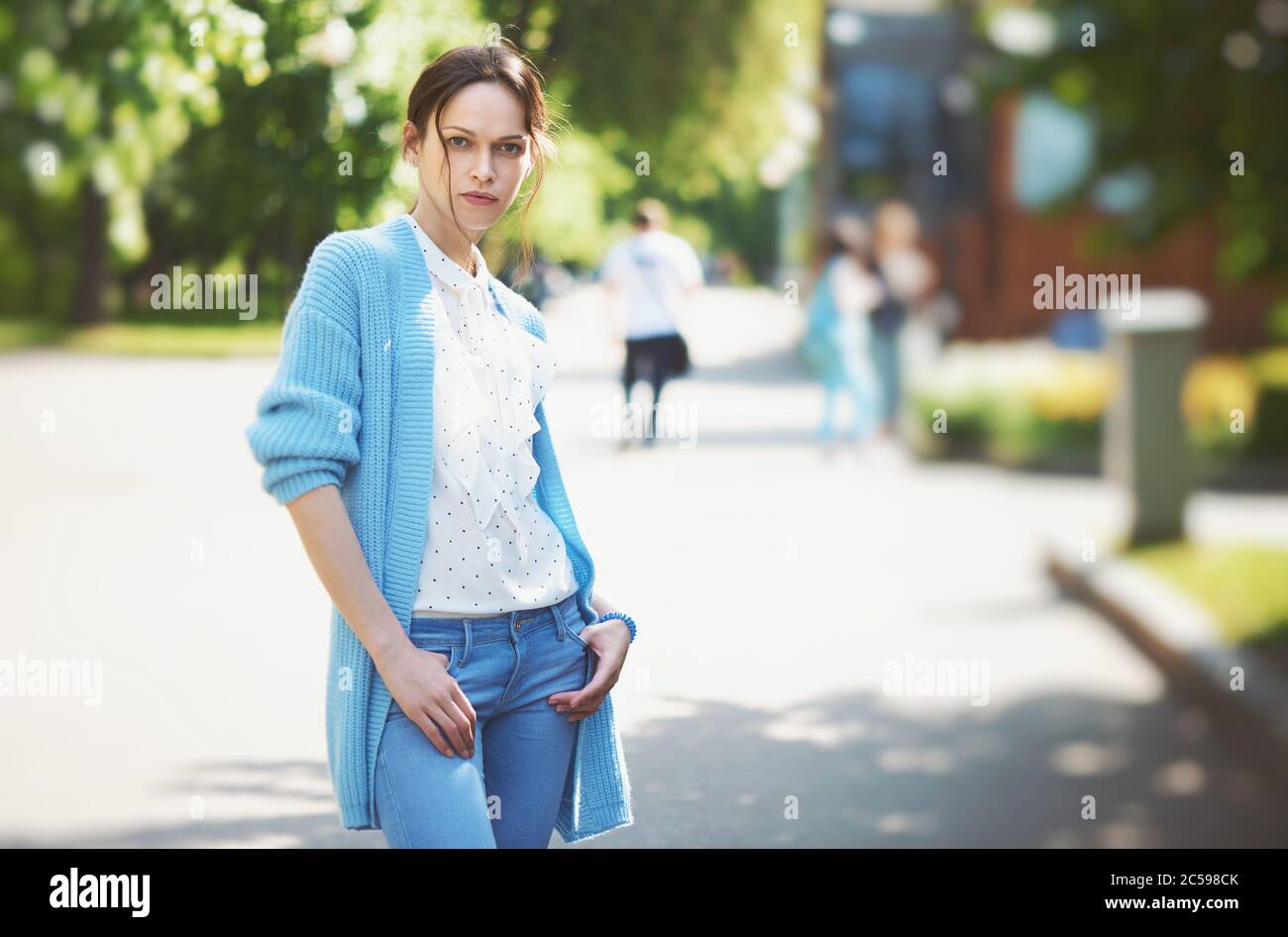 Portrait d'une femme confiante debout sur le parc de la ville. Jolie fille porte un pull tricoté Banque D'Images