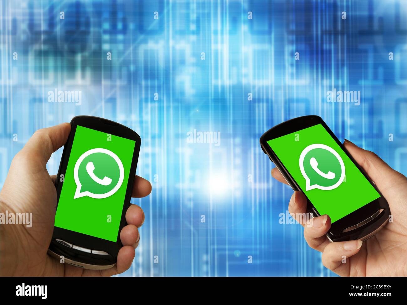 Mains tenant un smartphone avec le logo WhatsApp à l'écran Banque D'Images