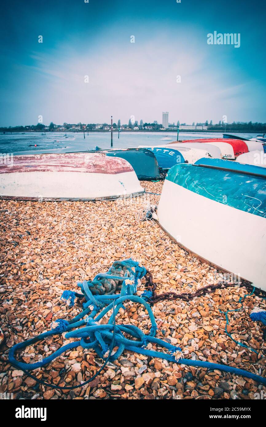 Bateaux de pêche en bois suréparés sur une plage de galets sur la rive Banque D'Images