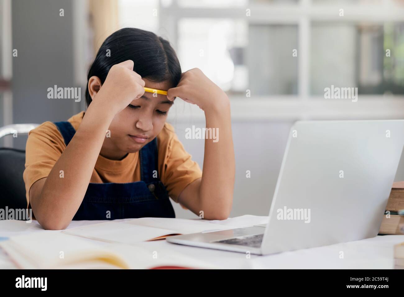 Bonne fille asiatique en ligne à la maison. Concept d'éducation et d'e-learning. Banque D'Images