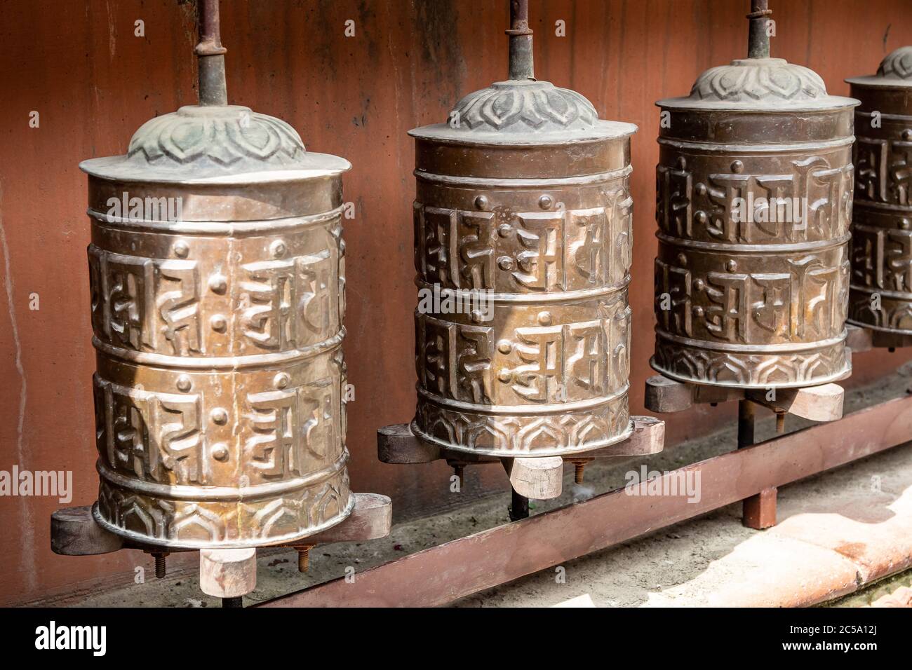 Les roues de prière le long du périmètre extérieur du temple bouddhiste balkumari, Thimi Banque D'Images