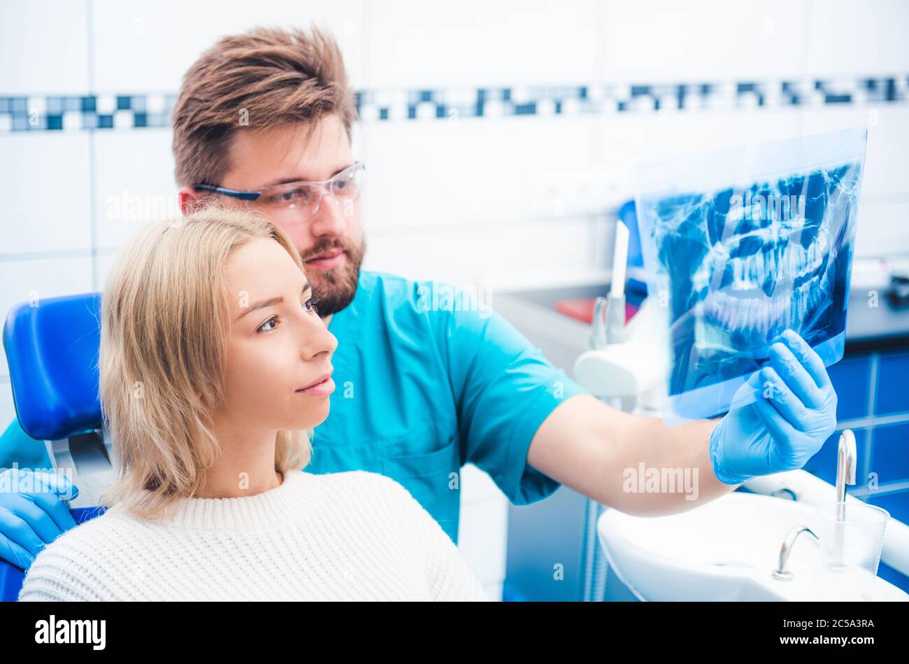 Médecin présentant un cliché de radiographie au patient Banque D'Images
