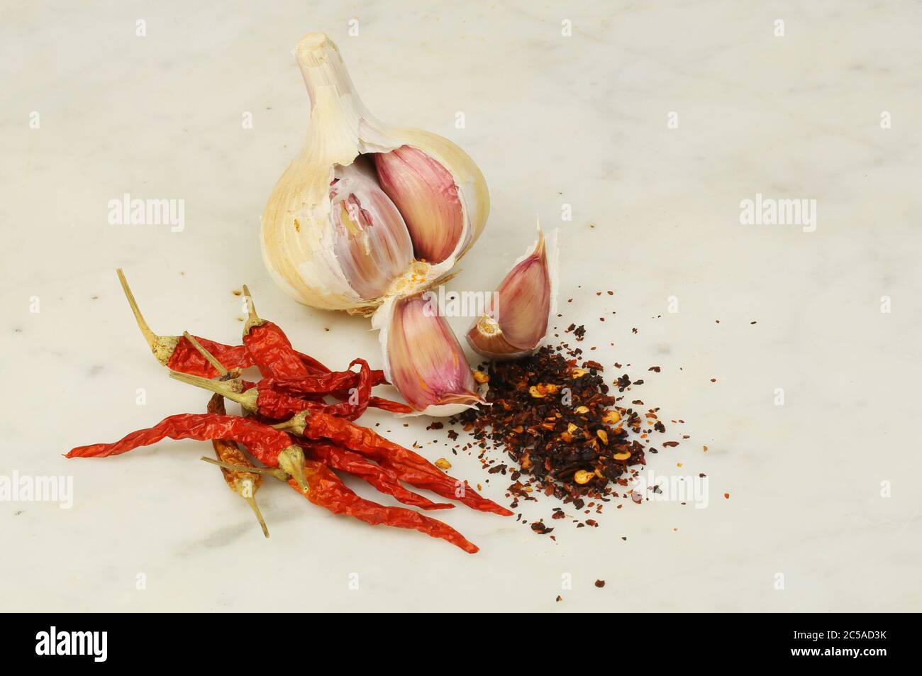 Bulbe d'ail et clous de girofle avec piments et flocons de piment séchés sur marbre Banque D'Images