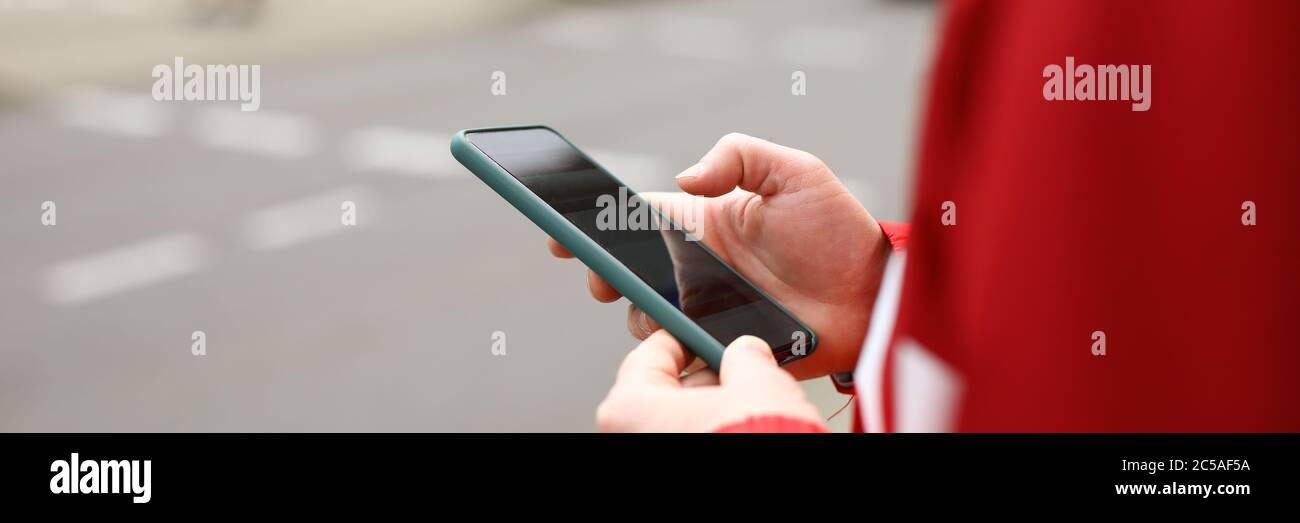 L'homme se tient à la croisée des chemins avec le téléphone entre ses mains Banque D'Images