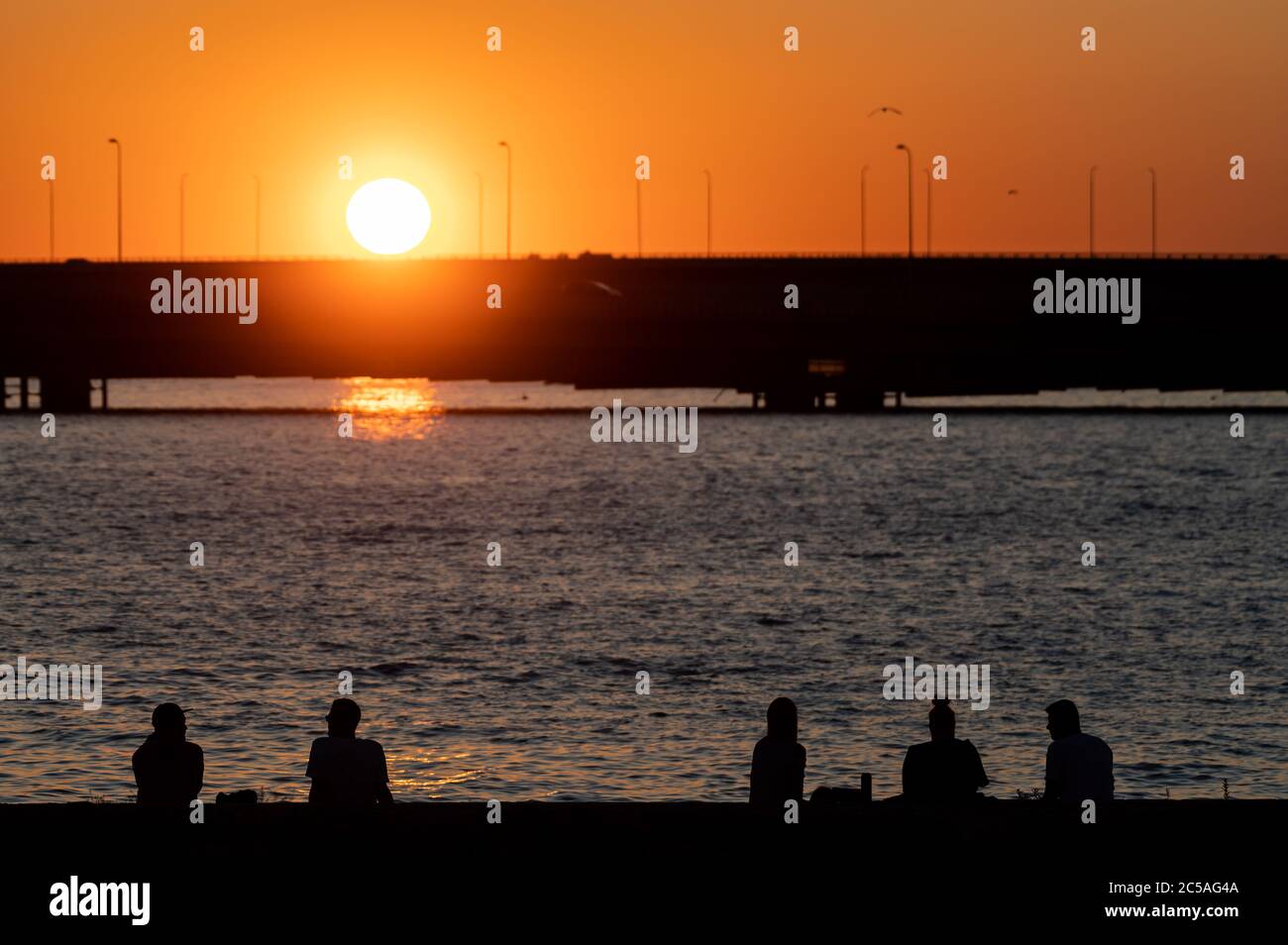 Helsinki / Finlande - 26 JUIN 2020 : silhouettes de gens heureux profitant du temps d'été sur terre au coucher du soleil. Banque D'Images