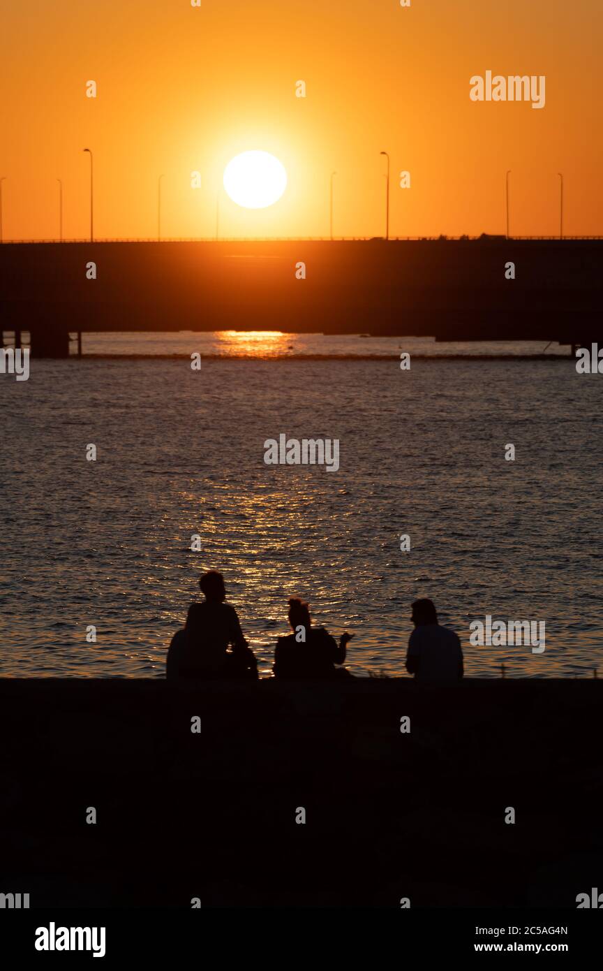 Helsinki / Finlande - 26 JUIN 2020 : silhouettes de gens heureux profitant du temps d'été sur terre au coucher du soleil. Banque D'Images