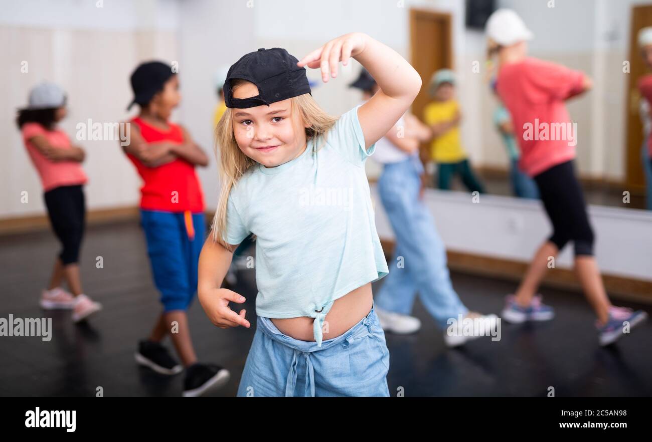 Petite fille danseuse de hip hop dans des vêtements décontractés et de  chapeau s'exerçant avec des amis au centre de danse Photo Stock - Alamy