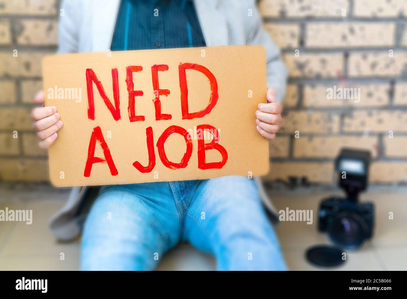 Photographe perdu son emploi. L'homme tient l'affiche dans ses mains - a besoin d'un travail. Le chômage est un problème social. Banque D'Images