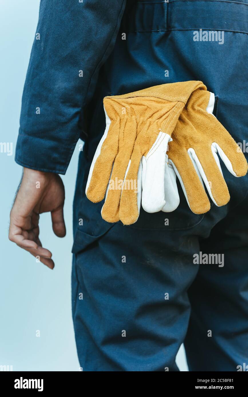 Gros plan sur les gants en cuir et mains du technicien mécanicien, en se tenant devant l'atelier d'entretien, préparation du technicien de maintenance pour le fixi Banque D'Images
