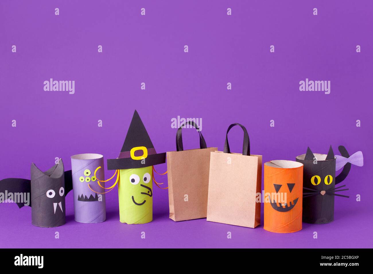 Automne saison Halloween vente concept - jouet de toilette rouleau tube recyclage idée et papier artisanat sac à provisions sur fond violet, écologique Banque D'Images