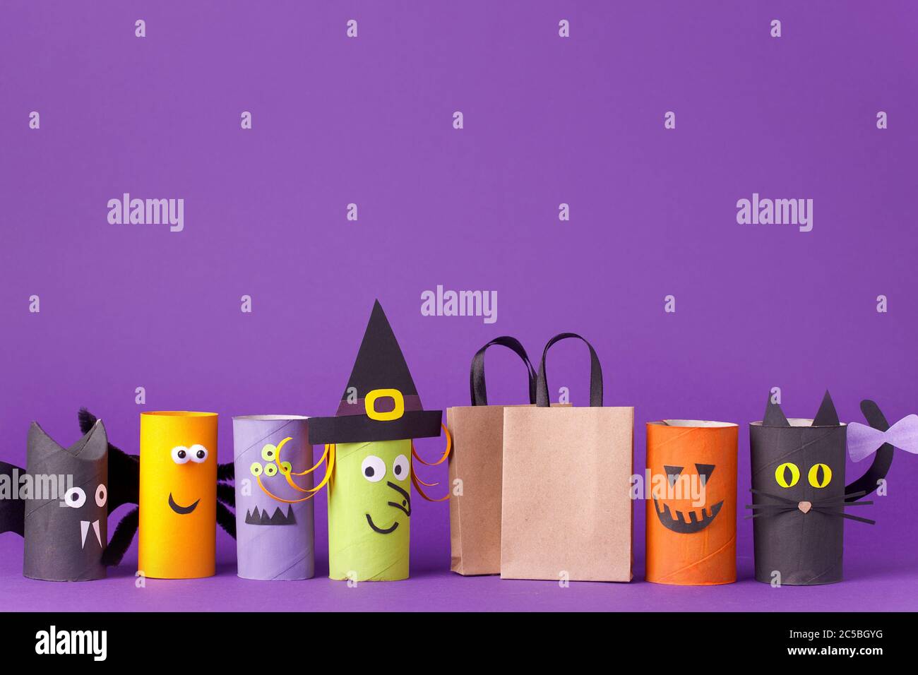 Automne saison Halloween vente concept - jouet de toilette rouleau tube recyclage idée et papier artisanat sac à provisions sur fond violet, écologique Banque D'Images