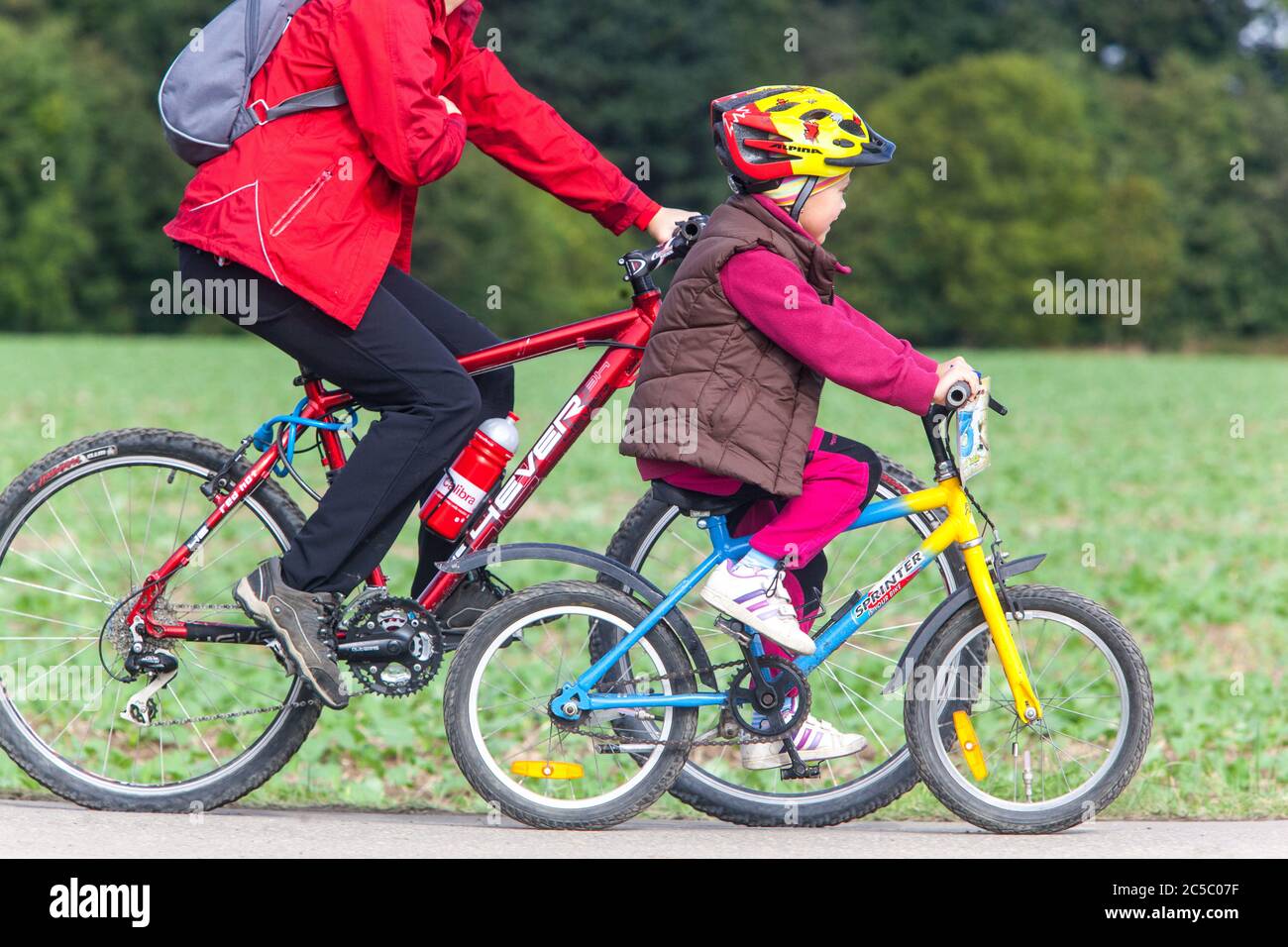 Vélo de randonnée pour enfant sur la piste cyclable, vélo pour enfant, casque, vélo d'équitation pour enfant avec casque casque casque de vélo pour enfant Banque D'Images